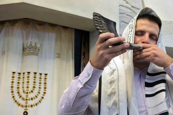 Rabino judeu toca shofar em uma sinagoga