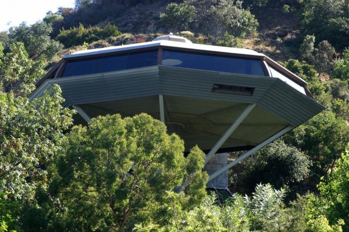 Uma casa de octógono que parece uma nave espacial empoleirada em árvores