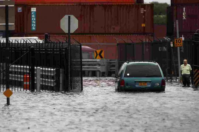 Uma pessoa caminha por uma rua inundada após o furacão Irene em 28 de agosto de 2011 no bairro de Red Hook, no bairro do Brooklyn, em Nova York.