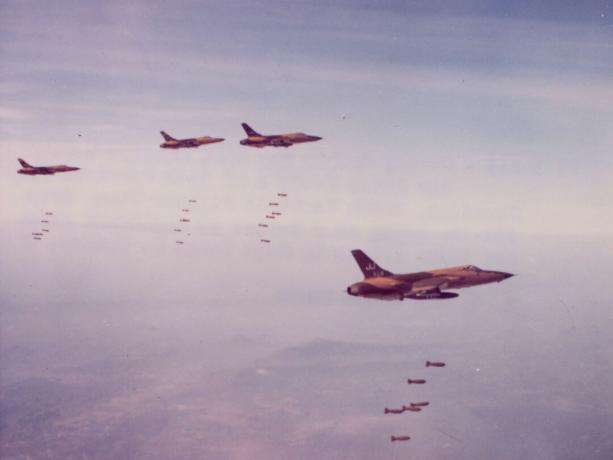 Quatro F-105 em camuflagem verde e marrom bombardeiam o Vietnã do Norte.