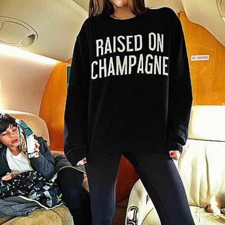 Uma foto postada no Rich Kids do Instagram mostra uma garota vestindo um moletom que diz "Criada em Champagne. "A teoria da interação simbólica nos ajuda a entender como essa camiseta e a foto dela criam significado na sociedade.