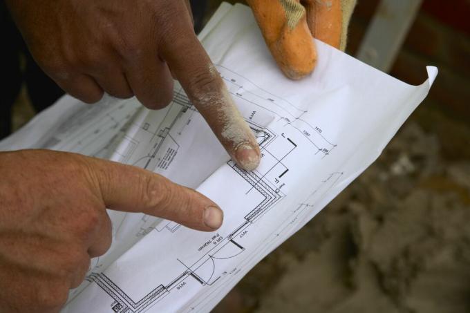 Trabalhadores da construção olhando planos, tudo que você vê são os dedos apontando