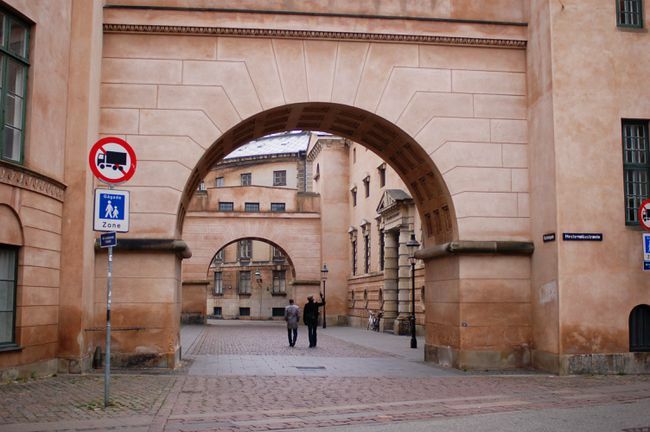 Pessoas passando por arcos antigos em Copenhague