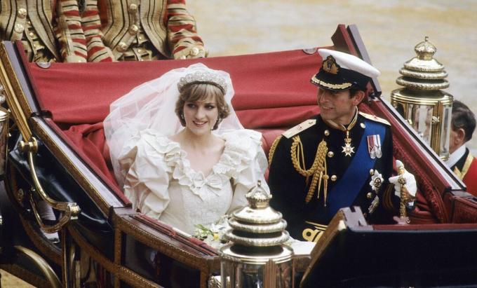 Princesa Diana e Príncipe Charles sentados juntos em uma carruagem após o casamento.