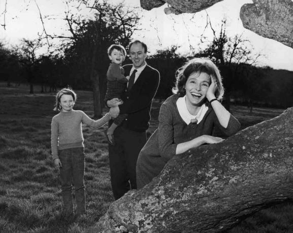 Foto em preto e branco de Roald Dahl segurando seus filhos; sua esposa Patricia Neal se apoia em uma árvore
