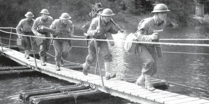 Soldados americanos cruzando uma pequena ponte de pontão.