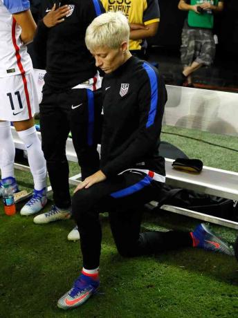 Fotografia da estrela feminina de futebol Megan Rapinoe ajoelhada durante o Hino Nacional