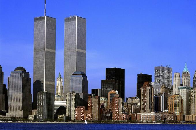 skyline da cidade com dois grandes arranha-céus dominantes, sólidos retangulares, um com torre no topo