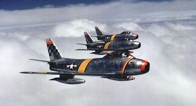 Três caças F-86 Sabre voando em formação.