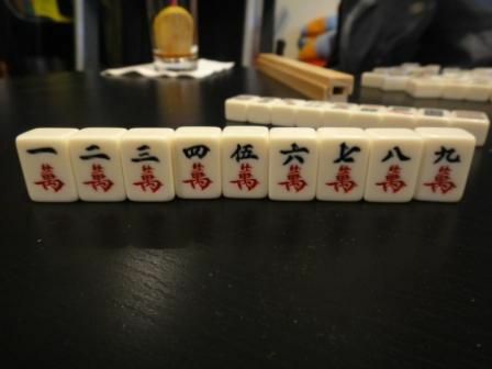 O traje de personagem de um conjunto de peças de Mahjong, sentado em uma mesa.