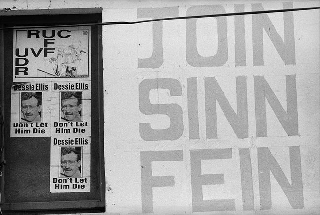 Cartazes na Irlanda do Norte apoiando o partido político Sinn Fein e comparando a força policial da Irlanda do Norte ao Exército Britânico.