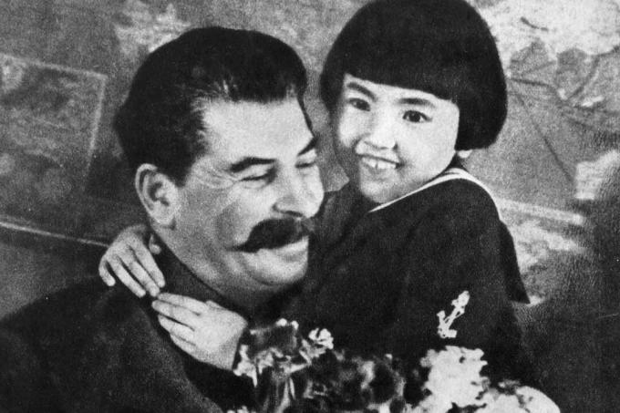 Joseph Stalin com uma criança que mais tarde foi enviada para um campo de trabalho