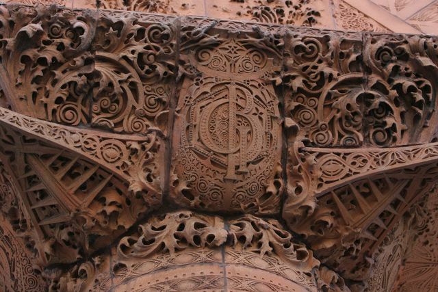 detalhes em terracota esculpidos em marrom, cachos ornamentados e monograma GB