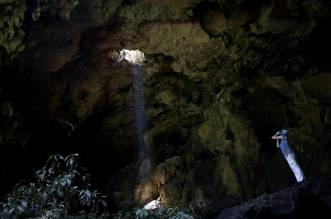 Um turista tira fotos na entrada da caverna de Calcehtok, em Oxkintok, estado de Yucatan, na península de Yucatan, no México.