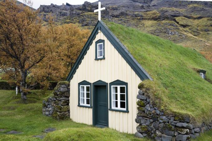 fachada pequena e branca da igreja com telhado de duas águas