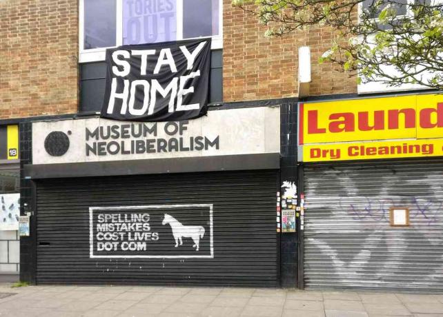 Grande sinal de STAY HOME acima do Museu fechado do Neoliberalismo em Lewsiham, Londres, Inglaterra.