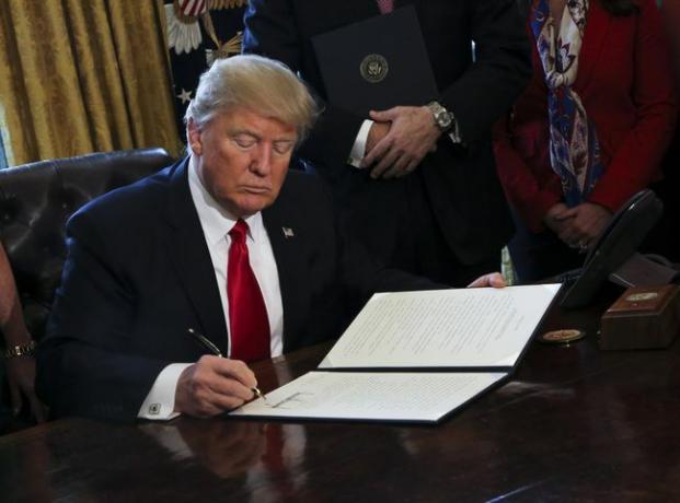 O presidente dos EUA, Donald Trump, assina ordens executivas, incluindo uma ordem para revisar o Dodd-Frank Wall Street para reverter os regulamentos financeiros da era Obama.